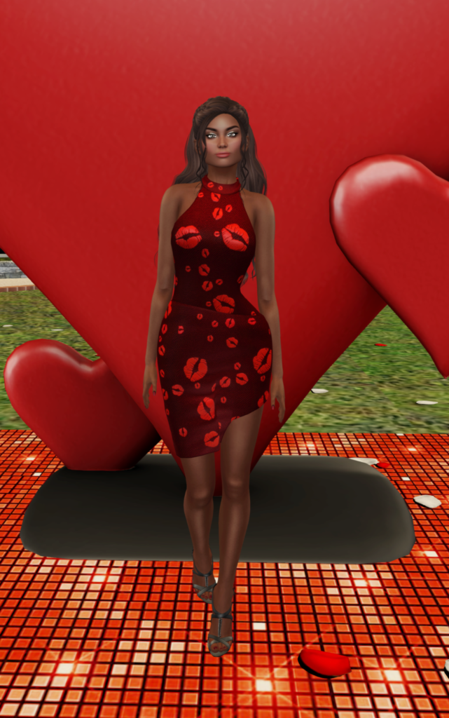A female Second Life avatar stands in front of a heart while wearing a red dress with lipstick kisses all over it.
