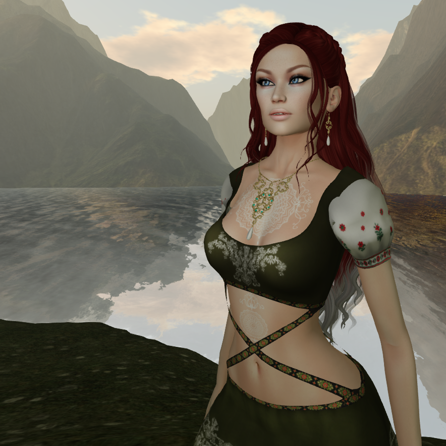 A female Second Life avatar with red hair stands in front of a lake in the mountains. She is wearing a celtic designed outfit with an open chest and straps over the stomach.