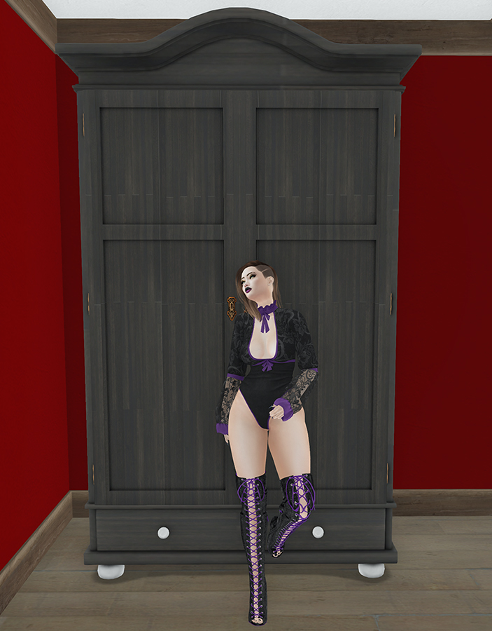 A Second Life avatar in black lace and boots stands in front of her Wardrobe.